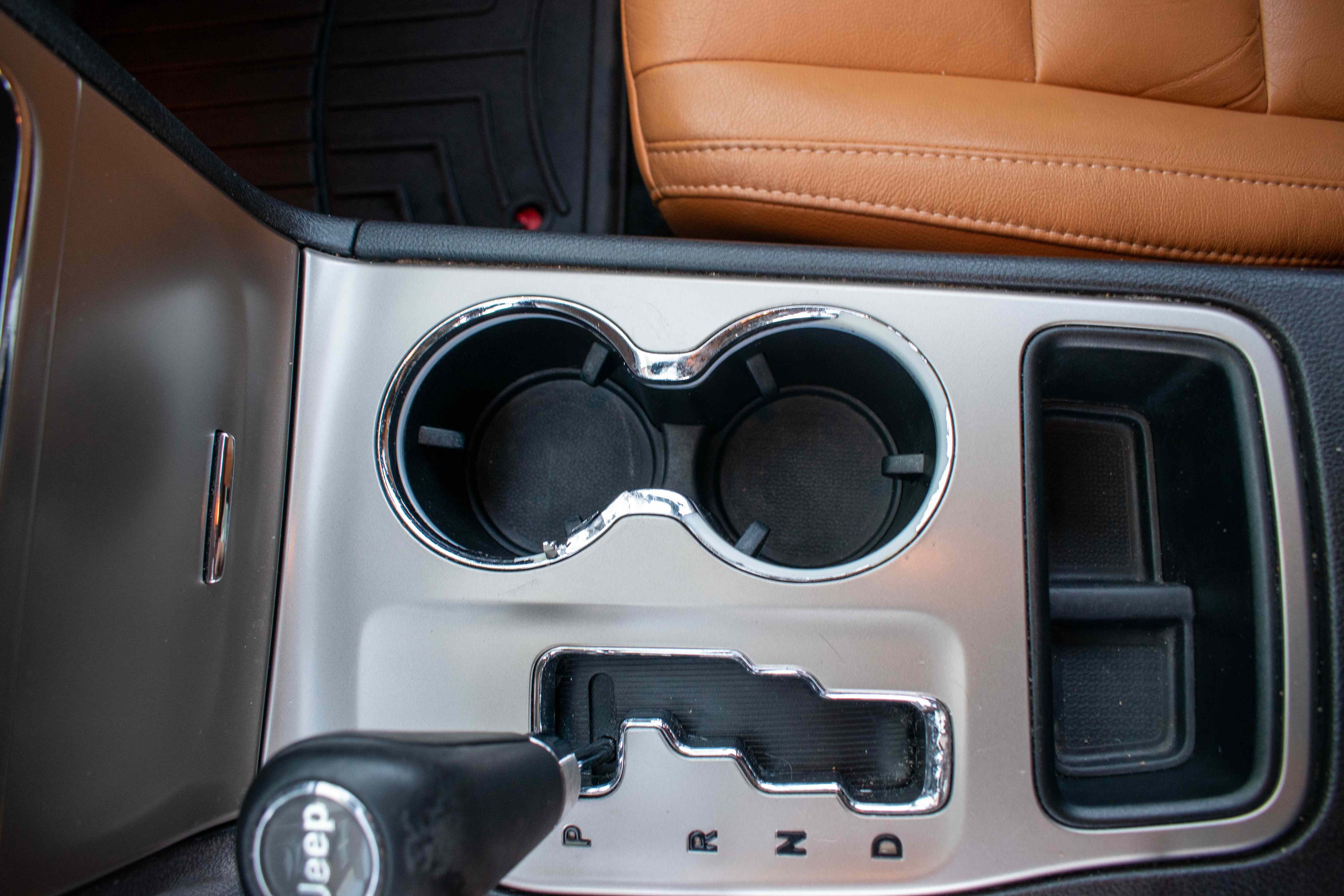 The same tan-seat vehicle center console, now clean after interior detailing
